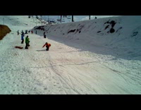 Snowboarder trick flips over snow ramp lands on ballooned cushion