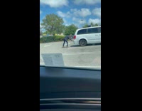 Man black jacket poses behind white vehicle
