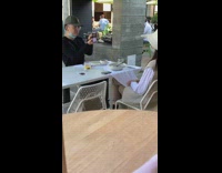 Woman white sweater vest hat restaurant hold camera
