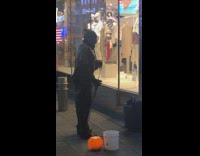 Man does bicep curls with resistance band on the sidewalk