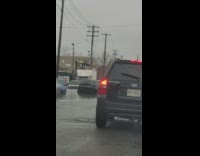 Car Turns Around from Flooded Road with Stalled Cars