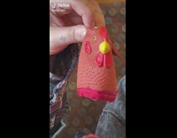 Woman pulls out red rooster coin purse out of rooster handbag