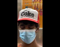 Guy riding subway wears coke hat 