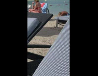 Guy blue shorts bend over stretch beach