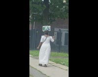 White dress lady water bottles on head 