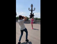 Woman in pink dress walk towards videographer