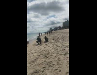 Long red dress lays on beach water 