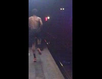 Shirtless guy runs in place at subway station, stops and takes a deep breath