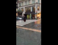 Woman black coat crosses road for video
