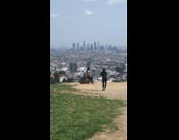 Girl leggings sit over large rock cityview