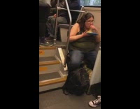 Woman eats spaghetti with bare hands out of plastic container on the bus