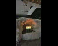 Candlelight vigil covered by a small snow cave 
