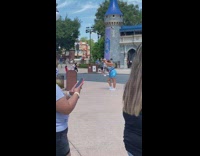 Woman blue shorts dance at magic kingdom 