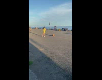 Yellow skirt girl phone tripod beach asphalt 