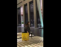 Woman posing with caution wet floor sign