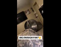 Couple using industrial fan in bedroom 