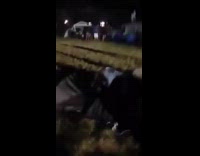 White Headband Guy Jumps Off Table Into Cardboard Box in Front of Tents