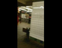 Man wears red vinyl dress and thigh high heels in subway station