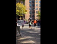 Woman holds power up sign for runners