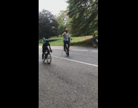 Guy rides unicycle with two metal sticks 