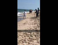 Man white formal attire music video beach