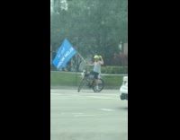 Man rides bike holds love elon flag