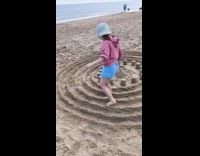 Girl walks around sand sculpture leave trail