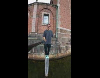 Guy jumps building side pole in water