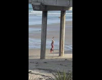 Woman in red bikini hangs upside down on the pole
