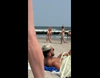 Man wrestling another man wearing bull mask at beach