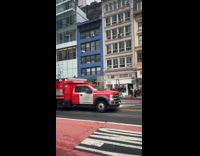 Two men rides construction bucket on street