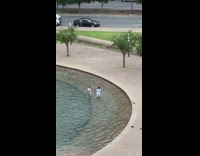 Couple in water fountain pool hold hands