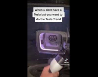 Guy taps his car and then puts charger into it 