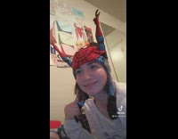 Girl with arm raising spiderman hat 