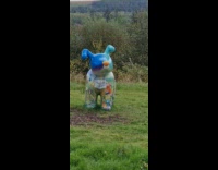 Dog barking at dog statue