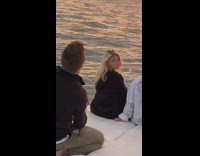 Two girls jacket sit front boat sunset