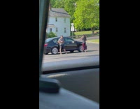 Girl records dance video next to car and guy 