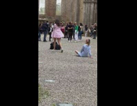 Two women sits on the ground in front of the tripod
