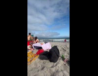 Shirtless man doing fighting stances at beach
