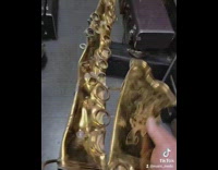 Guy shows a flattened saxophone 
