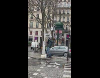 Guy black coat middle street rain pillar