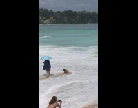 Woman in bikini got caught by the beach wave