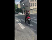 Guy rides motorcycle with dog in backpack 