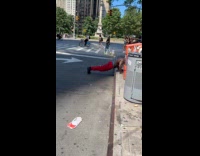 Shirtless man push ups on street curb