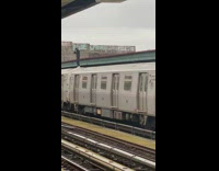 Guy standing atop departing subway train to subway surf