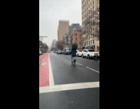 Man bikes in city holds Christmas tree
