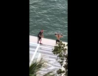 Black leggings girl squats edge of rooftop 