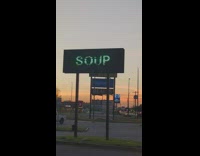 Woman reads changing soup sign 