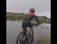 man in full bike gear drives into lake