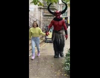 Girl holds hands with red devil guy
